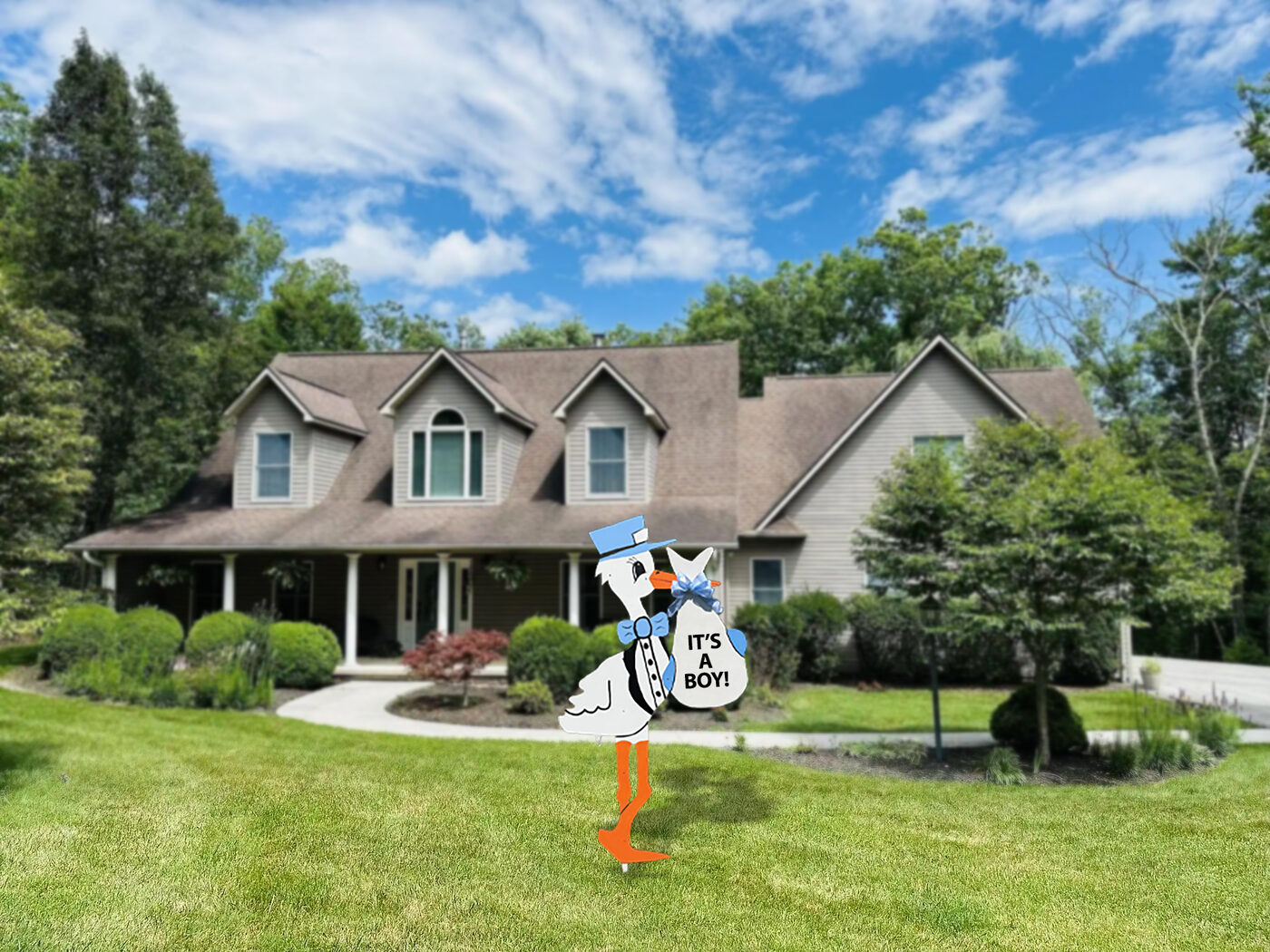 Blue stork sign reading It's a Boy in a front yard.