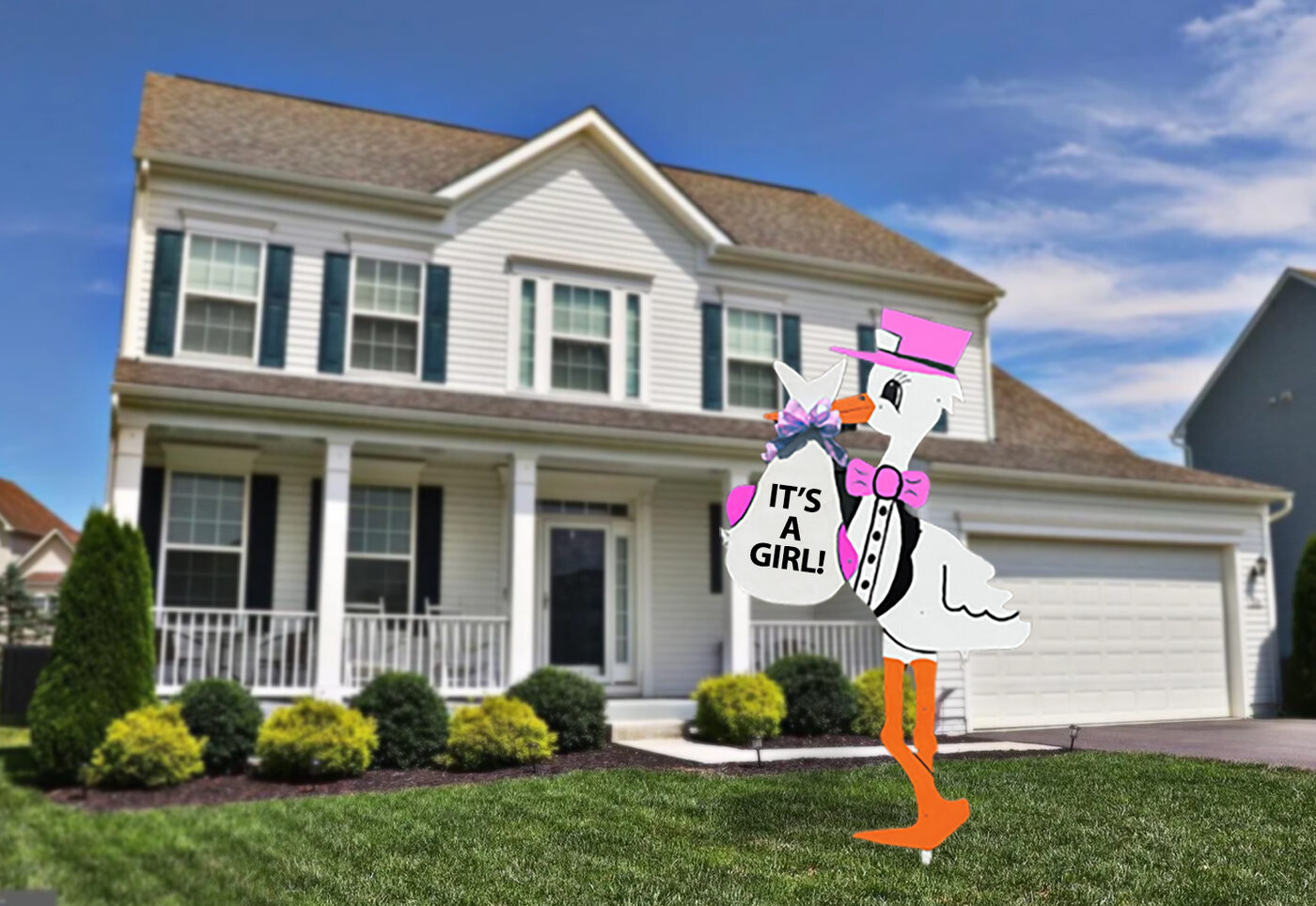 Pink stork sign reading It's a Girl in a front yard.